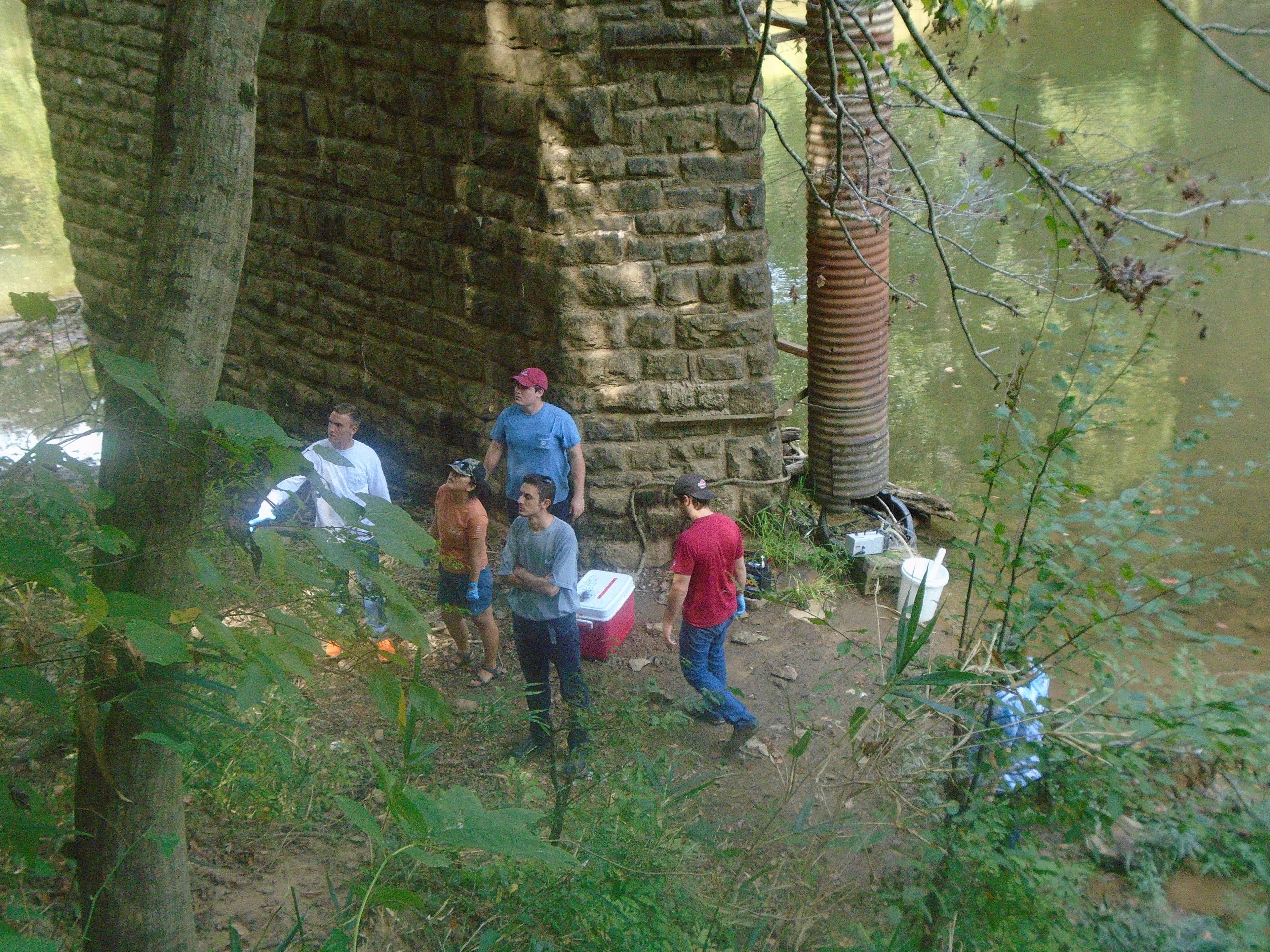Students performing water collection fieldwork with Dr. Lu.