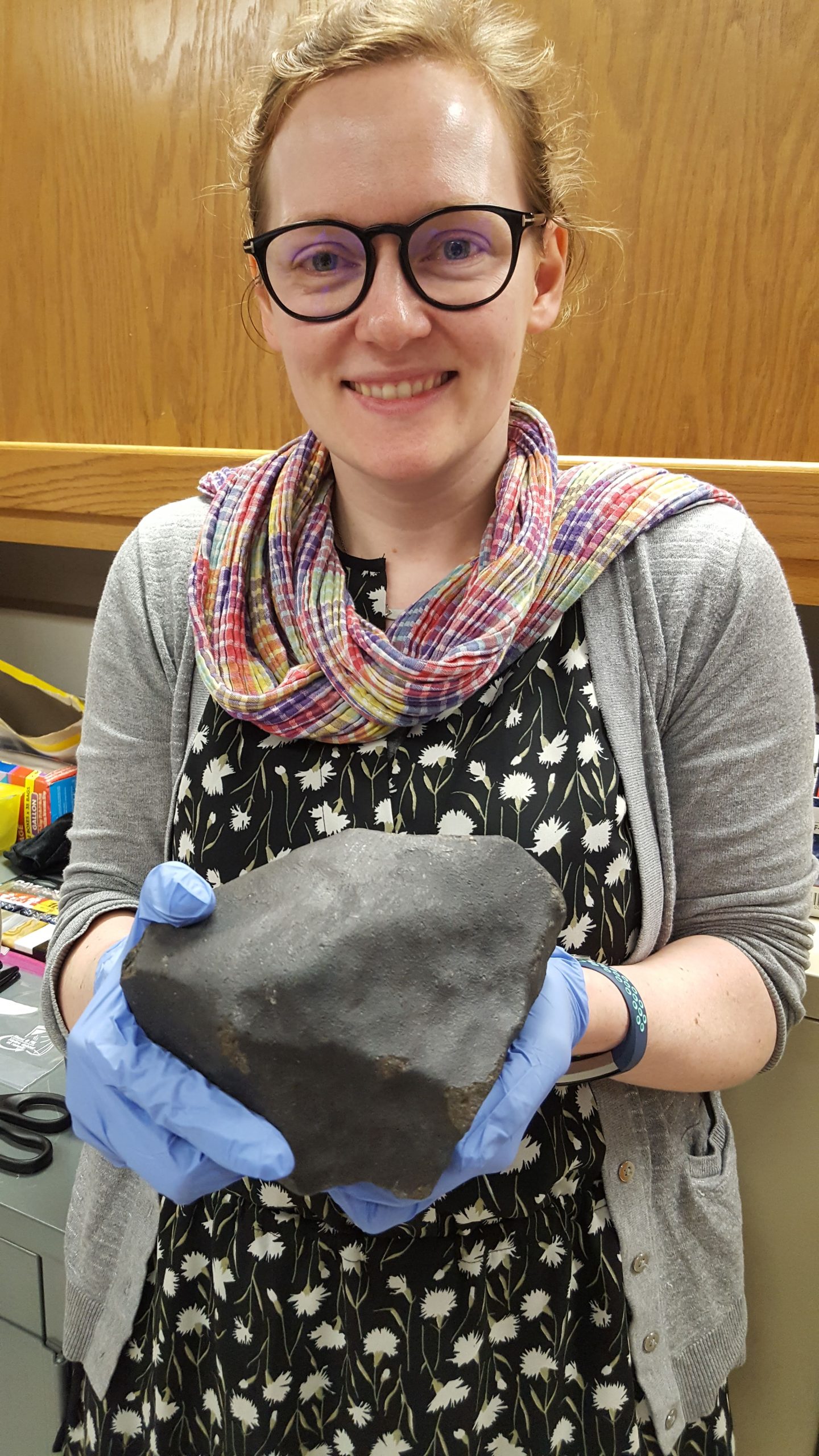 Dr. Cartwright in the lab, holding the Sylacauga Meteorite.